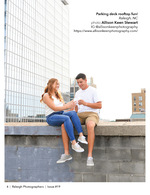 couple sitting on a parking deck ledge above the skyline couples portrait photography