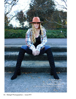 woman in a wide-brim hat seated on stone steps fashion photography