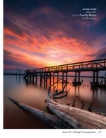 pier and driftwood under a fiery sunset sky landscape photography